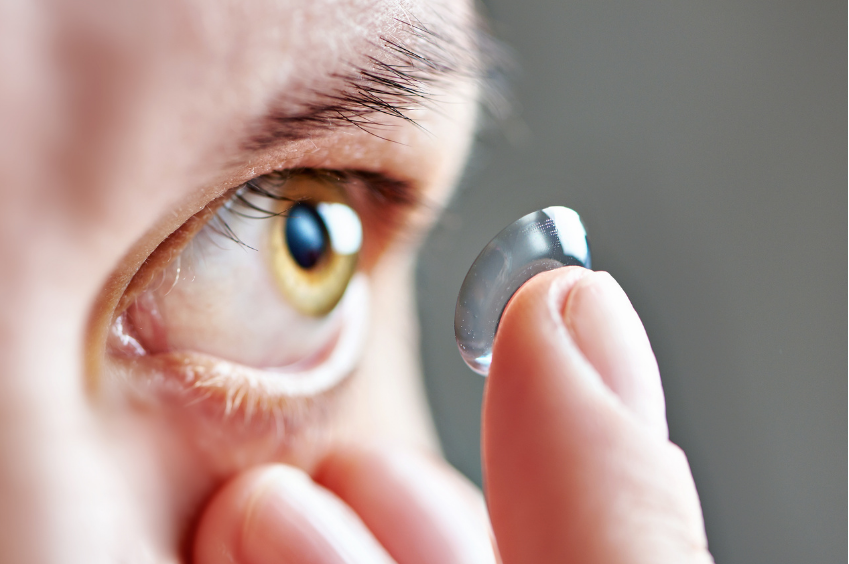 person putting a contact lens in their eye