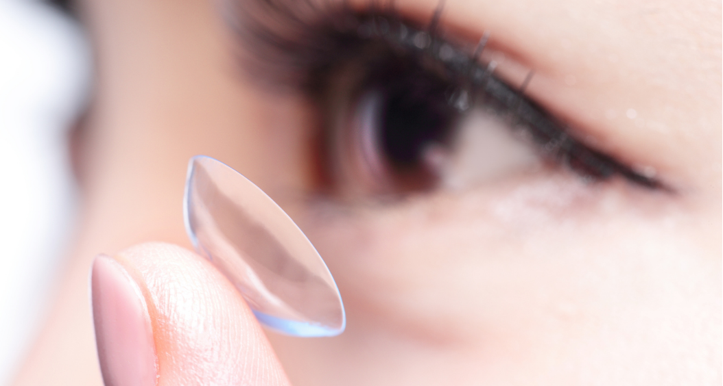 person putting a contact lens in their eye
